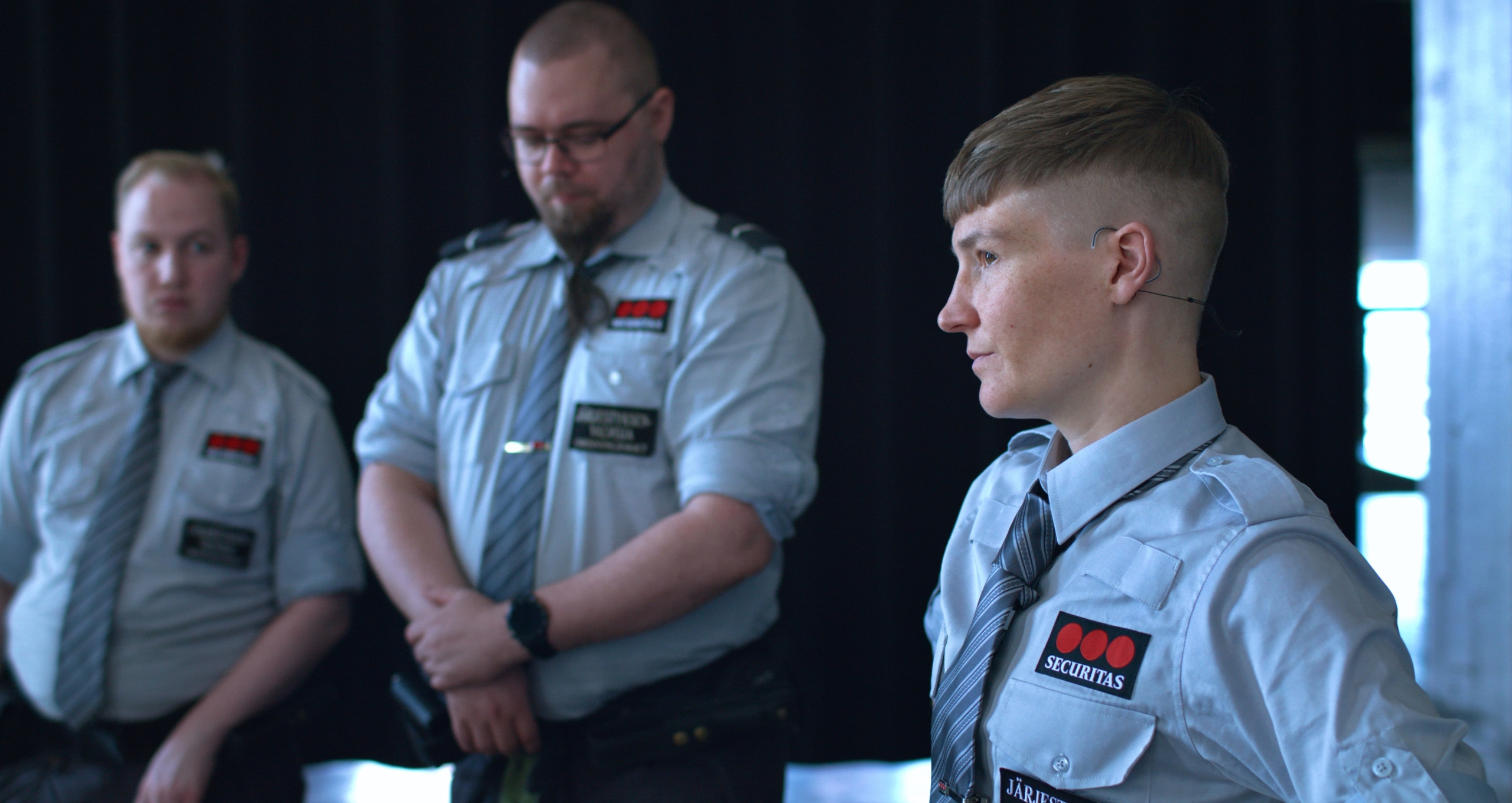 There are three people in a guard suit. The one in the front is artist Pilvi Takala.