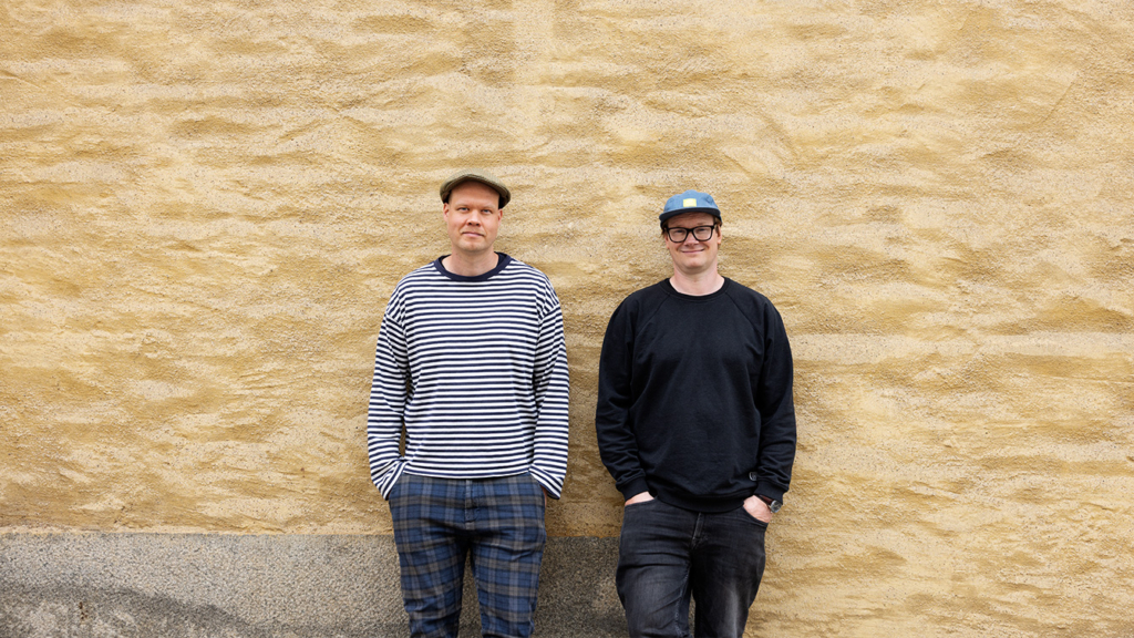 Markus Leppälä ja Artur Franck nojaavat keltaiseen seinään.